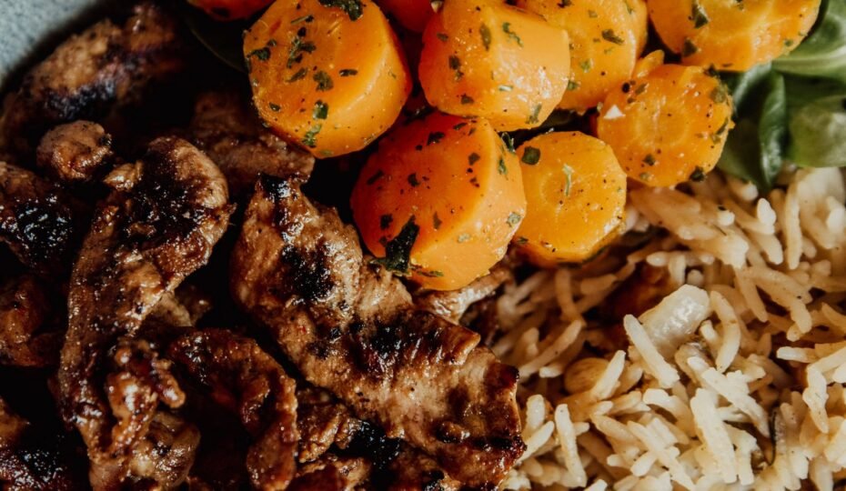 Primer plano de un plato con carne, arroz y zanahorias